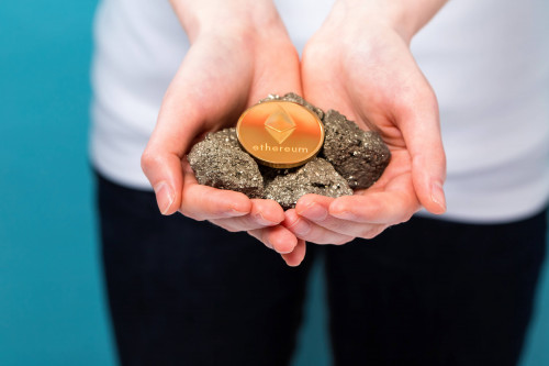 Woman with a ethereum with raw gold nuggets