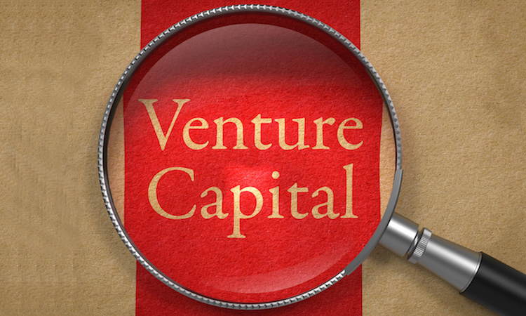 Venture Capital through Magnifying Glass on Old Paper with Red Vertical Line.