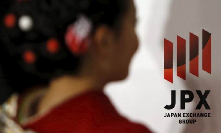 A logo of Japan Exchange Group Inc. is seen next to a woman before the New Year opening ceremony at the Tokyo Stock Exchange