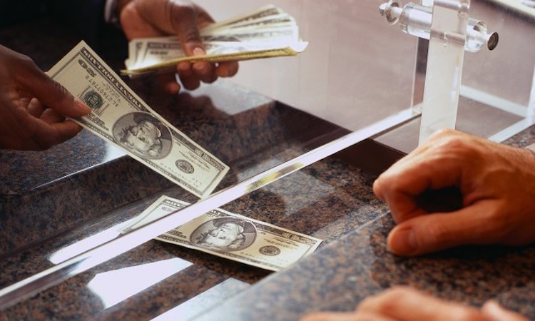 Bank Teller Counting Money for Customer